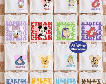 May include: A collection of white t-shirts featuring various Disney character graphics, including Daisy Duck, Mickey Mouse, Buzz Lightyear, Ariel, Eeyore, Winnie the Pooh, Cinderella, and Chip, paired with personalised names and colourful wavy text.