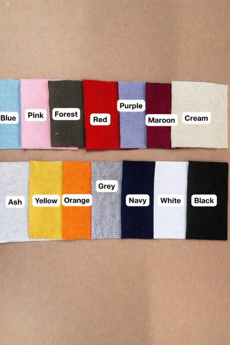 May include: A collection of fabric swatches in various colors, including blue, pink, forest green, red, purple, maroon, cream, ash, yellow, orange, grey, navy, white, and black. Each swatch has a label with its color name.