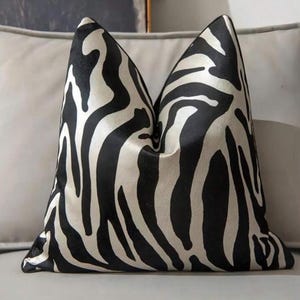 May include: A black and white zebra patterned throw pillow with a soft, plush texture.