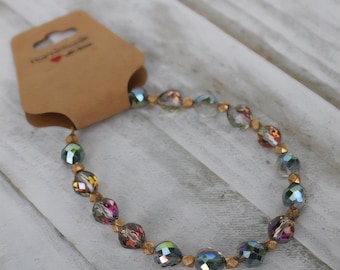 Pulsera de cuentas de cristal iridiscentes con cierre de palanca con detalles dorados. Hecha a mano.