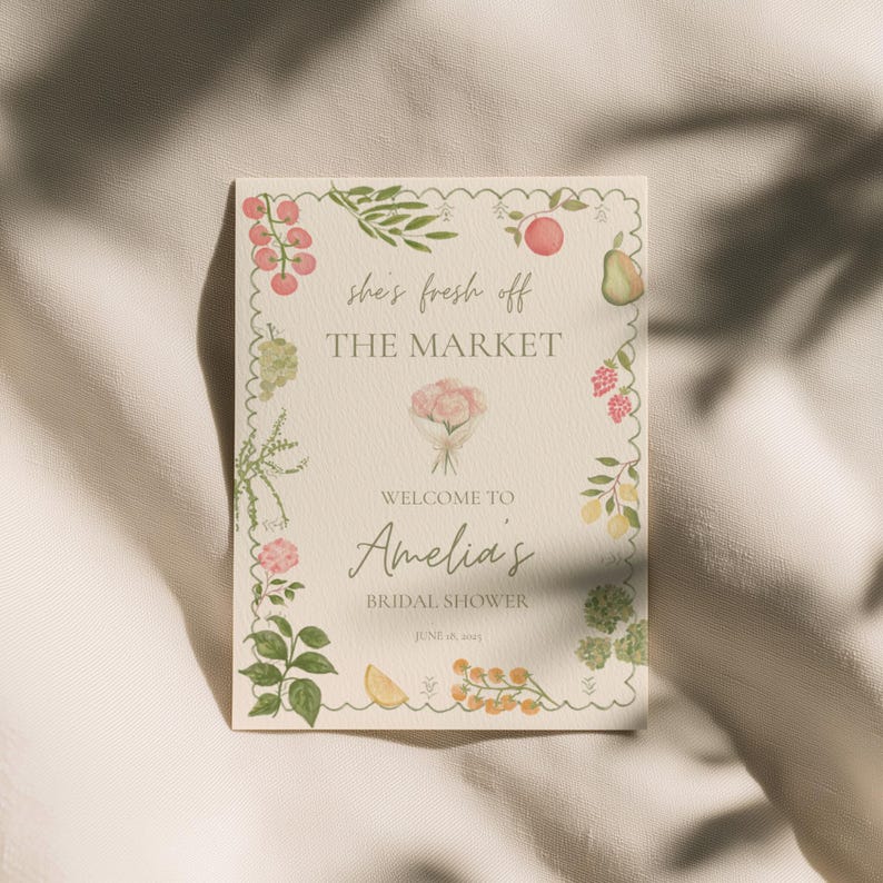 Peut inclure: Une invitation rectangulaire avec une bordure festonn&eacute;e, orn&eacute;e d'illustrations &agrave; l'aquarelle de fruits et de feuillages. Le texte indique "she's fresh off THE MARKET" et "Welcome to Amelia's Bridal Shower."
