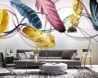 May include: A living room interior design with a gray sofa and a coffee table. The wall features a colorful abstract mural with stylized feathers in shades of pink, blue, yellow, and gold. The mural is set against a white background with delicate, translucent lines.