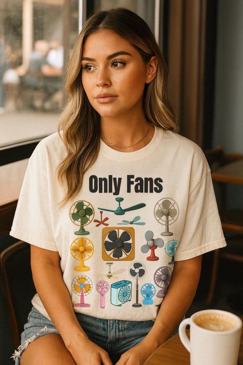 May include: Cream-colored t-shirt with the text "Only Fans" in black block letters. The shirt features a colorful graphic of various fans, including ceiling fans, oscillating fans, and box fans.