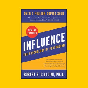 Puede incluir: Portada de libro con fondo amarillo. El título "INFLUENCE" se muestra de forma destacada en letras blancas grandes sobre un fondo azul y morado. El libro se titula "THE PSYCHOLOGY OF PERSUASION" de Robert B. Cialdini, Ph.D.