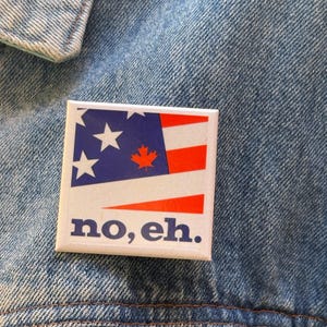May include: A square pinback button featuring a graphic design that combines elements of the American and Canadian flags, with a blue field, white stars, red and white stripes, and a red maple leaf. The text "no, eh." is printed in blue.