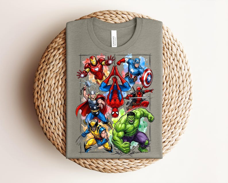 May include: A grey t-shirt with a vibrant graphic of Marvel superheroes, such as Iron Man, Captain America, Spider-Man, Thor, Wolverine, Hulk, and Deadpool. The design is set against a watercolour-style background.