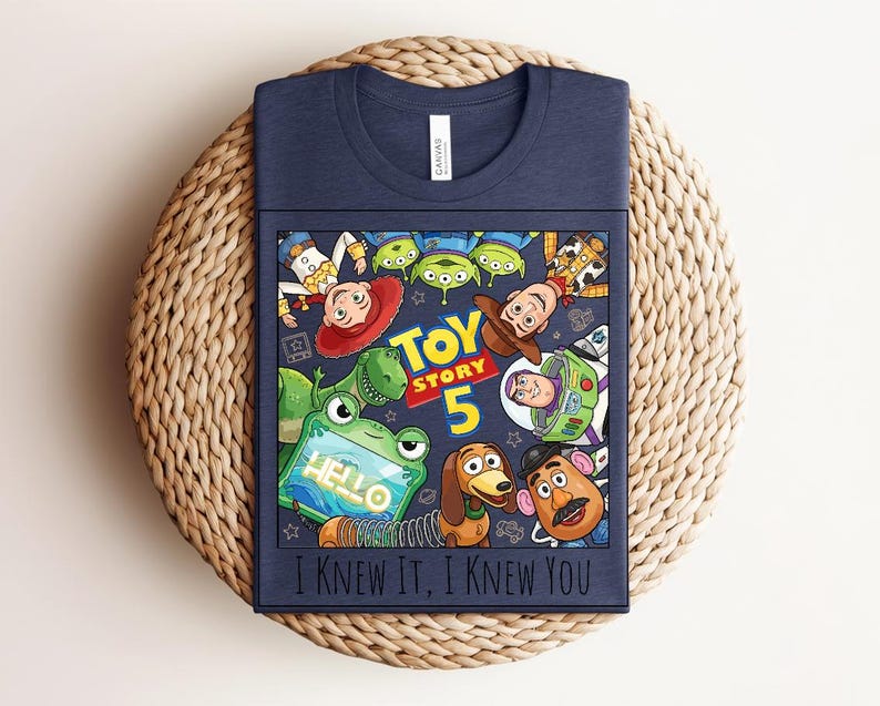 K&ouml;nnte beinhalten: Ein marineblaues T-Shirt mit einem Grafikdruck von Toy Story-Figuren, darunter Woody, Buzz Lightyear, Jessie, Rex, Slinky Dog, Mr. Potato Head und die Aliens. Der Text lautet "TOY STORY 5" und "I KNEW IT, I KNEW YOU" mit einem gr&uuml;nen Tablet.