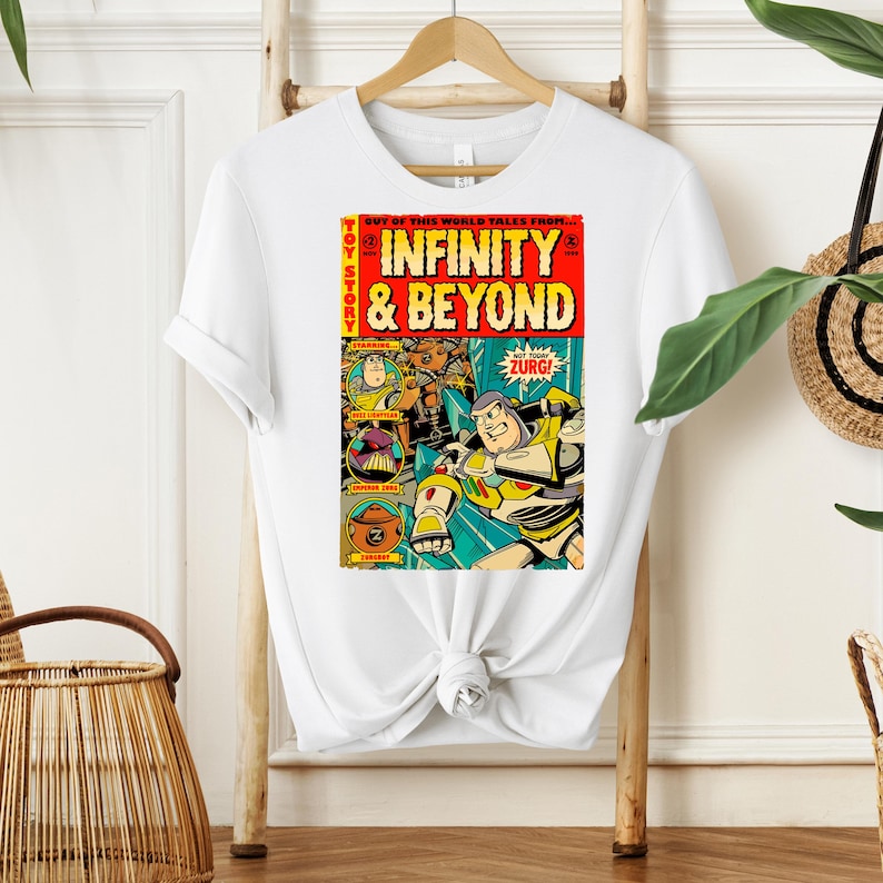 Puede incluir: Una camiseta blanca con un dise&ntilde;o de c&oacute;mic vintage con Buzz Lightyear de Toy Story. La portada del c&oacute;mic dice "Toy Story: Infinity & Beyond" con un esquema de color rojo y amarillo.