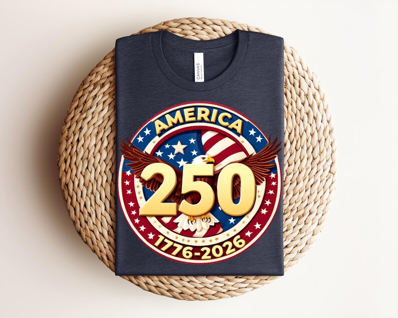 May include: A navy blue t-shirt with a circular graphic featuring the word "AMERICA", stars, stripes, and the number "250" in gold. The graphic includes an eagle and the dates "1776-2026".