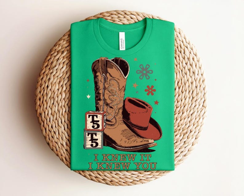 May include: A bright green t-shirt featuring a brown cowboy boot, a brown cowboy hat, and two stacked blocks with the text T5. The graphic includes small star and flower shapes in red and brown. The text I KNEW IT I KNEW YOU is printed below.