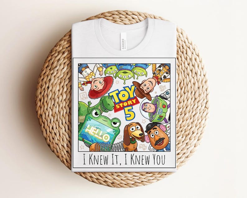 K&ouml;nnte beinhalten: Ein wei&szlig;es T-Shirt mit einem farbenfrohen Grafikdruck der Toy Story-Figuren, darunter Woody, Buzz Lightyear, Jessie, Rex, Slinky Dog, Mr. Potato Head und die Aliens. Der Text lautet TOY STORY 5 und I KNEW IT, I KNEW YOU.