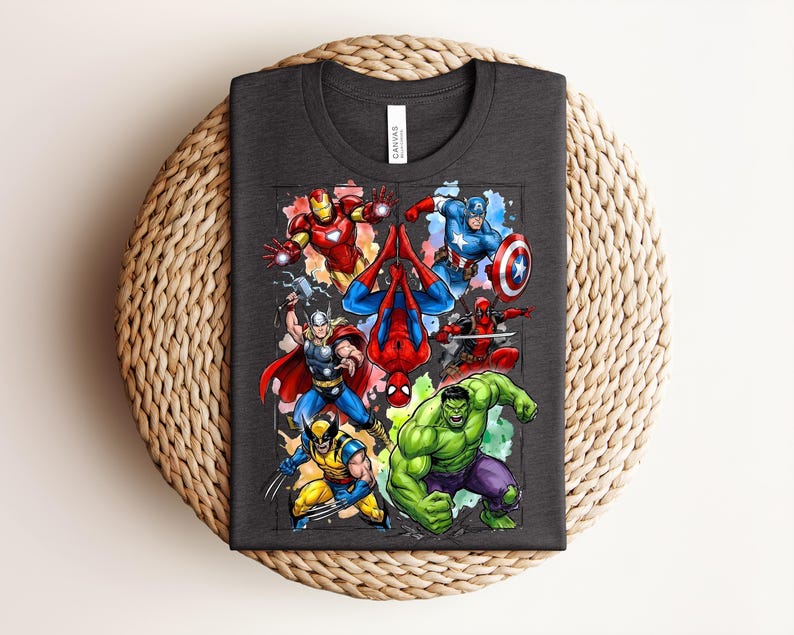 May include: Dark grey t-shirt with a vibrant graphic of Marvel superheroes, such as Iron Man, Spider-Man, Captain America, Thor, Wolverine, Deadpool, and the Hulk. The tee is made of a soft material and is suitable for casual wear.