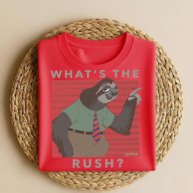 Puede incluir: Camiseta roja de cuello redondo con un perezoso de dibujos animados de Zootopia. El perezoso lleva una camisa verde y una corbata a rayas, con el texto "WHAT'S THE RUSH?" encima y debajo de la imagen. La camiseta se muestra sobre una estera tejida.