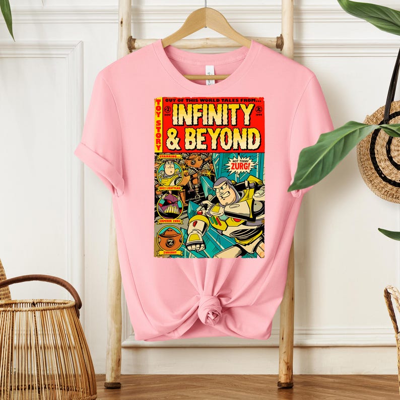 Puede incluir: Camiseta rosa con un dise&ntilde;o de c&oacute;mic vintage con personajes de la franquicia Toy Story. La portada del c&oacute;mic dice "Toy Story: Infinity & Beyond" con una imagen de Buzz Lightyear y otros personajes.