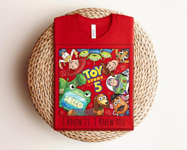 K&ouml;nnte beinhalten: Ein rotes T-Shirt mit einem Grafikdruck von Toy Story-Figuren, darunter Woody, Buzz Lightyear, Rex, Slinky Dog, Mr. Potato Head und gr&uuml;ne Aliens. Der Text lautet Toy Story 5 und I Knew It, I Knew You. Das Shirt hat einen Rundhalsausschnitt.