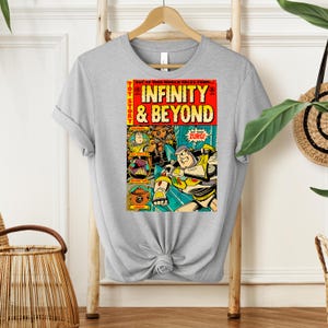 Puede incluir: Una camiseta gris con un dise&ntilde;o de portada de c&oacute;mic vintage con personajes de la franquicia Toy Story. La portada del c&oacute;mic se titula "Infinity & Beyond" y presenta a Buzz Lightyear y otros personajes de la pel&iacute;cula.