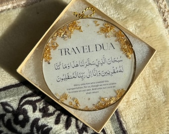 Puede incluir: Una dua de viaje circular blanca con detalles de pan de oro en una caja marrón claro. La dua dice: "Gloria a Aquel que creó este transporte para nosotros, aunque no pudimos crearlo por nuestra cuenta. Y hacia nuestro Señor volveremos." El texto está en árabe e inglés.