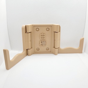 May include: A beige, 3D-printed wall mount display stand featuring two horizontal arms and a central rectangular plate. The central plate displays the Japanese kanji characters 白樺 in relief, with four circular screw holes at the corners.