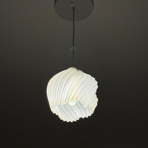 Peut inclure: Un luminaire suspendu blanc à nervures suspendu à un plafond avec une plaque de plafond circulaire blanche.