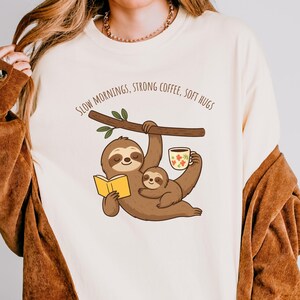 ママ・ナマケモノ ユニセックスTシャツ | ゆっくりとした朝、濃いコーヒー、柔らかなハグ、心地よい色彩 1717