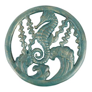 May include: A teal-colored, circular metal wall art piece featuring a seahorse, seaweed, and waves. The seahorse is in the center, surrounded by a decorative frame. The piece has a distressed, antique finish.