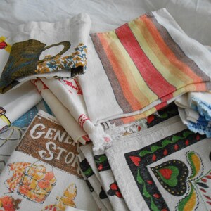 May include: A collection of vintage fabric napkins and cloths. Some napkins feature colorful stripes, floral patterns, and text that reads "General Store". Other napkins have images of a teapot, and a blue and white design.