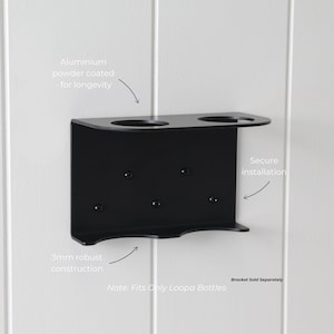 May include: A black, powder-coated aluminum bracket designed to hold two bottles. The bracket features a robust 3mm construction and is designed for secure installation. The text on the image says "Note: Fits Only Loopa Bottles."