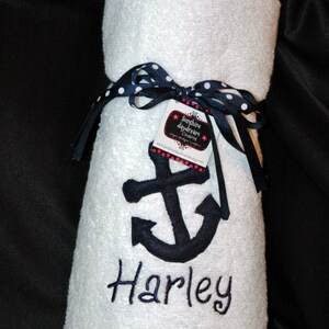May include: White hooded towel with a navy blue anchor and the name "Harley" embroidered on it. The towel is tied with a black and white polka dot ribbon and a tag that reads "Sunshine Daydream Creations".