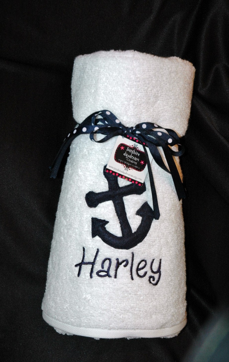 May include: White hooded towel with a navy blue anchor and the name "Harley" embroidered on it. The towel is tied with a black and white polka dot ribbon and a tag that reads "Sunshine Daydream Creations".