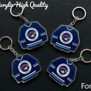 May include: Four acrylic keyrings shaped like blue hockey jerseys with white and light blue stripes. Each keyring features the text "Briar University Hawks" and a hawk logo. The text "Acrylic High Quality" is at the top.