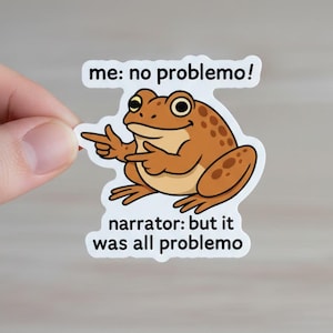May include: A sticker featuring a cartoon frog with the text "me: no problemo!" and "narrator: but it was all problemo." The frog is brown with darker spots and is pointing with both hands. The sticker has a white border.