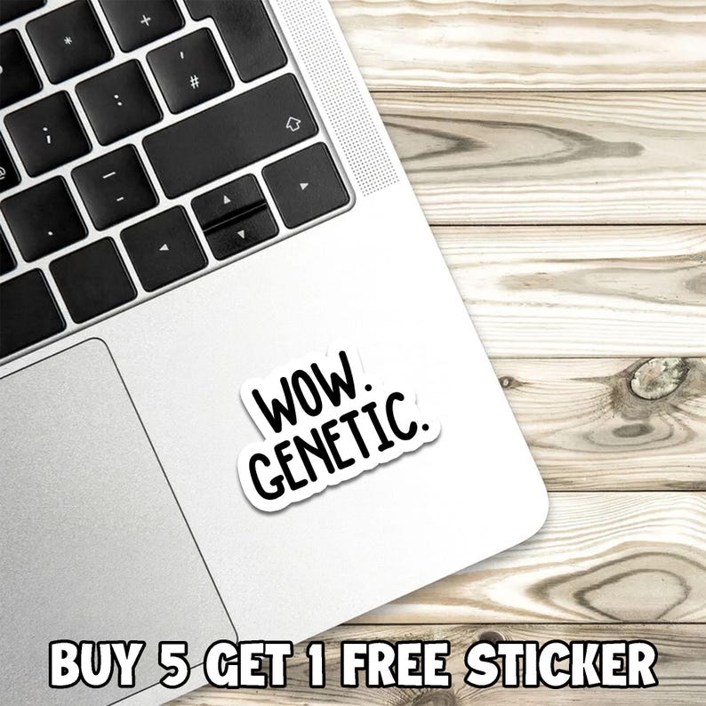 Op de afbeelding: Een witte sticker met de woorden "WOW. GENETIC." in een zwarte, vette letter. De sticker staat op een zilveren laptop, met een houten achtergrond. De tekst "BUY 5 GET 1 FREE STICKER" staat onderaan.