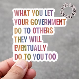 Puede incluir: Una pegatina multicolor con el texto "WHAT YOU LET YOUR GOVERNMENT DO TO OTHERS THEY WILL EVENTUALLY DO TO YOU TOO." La pegatina está sujeta por una mano. Una pequeña pegatina circular dice "Buy 5 Get 1 Sticker Free".