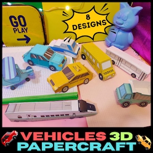 Puede incluir: Una colección de vehículos de papel 3D, incluyendo un coche azul, un taxi amarillo, un autobús escolar, un avión y un tren. La imagen muestra el texto "8 DESIGNS" y "VEHICLES 3D PAPERCRAFT". También hay una figura de gato azul.