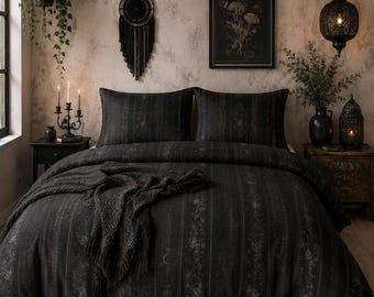 May include: A dark charcoal gray bedding set featuring a vertical striped pattern with subtle floral motifs and a crescent moon icon. The set includes a duvet cover and two matching pillowcases, draped with a textured dark gray knit throw blanket.