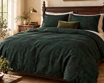 May include: A dark forest green duvet cover and two matching pillowcases featuring a subtle, tonal floral pattern. A small, rectangular olive green velvet accent pillow is centered in front of the two larger pillows on the bed.