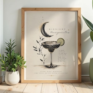 May include: A framed wall art print featuring a black and white illustration of a margarita glass with a lime slice, a crescent moon, and botanical sprigs. The text reads Midnight Margaritas, a cocktail recipe, and the phrase Sisters, Magic, Margaritas.