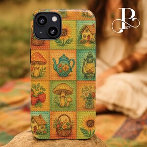 May include: A colorful phone case featuring a patchwork design with illustrations of mushrooms, sunflowers, houses, and a teapot. The case has a textured appearance and a protective design, perfect for a mobile phone.