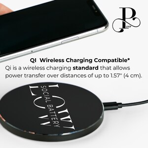 May include: A black wireless charging pad with the text "LUW SOCIAL BATTERY LOW" printed in white. The pad is compatible with Qi wireless charging, which allows for power transfer over distances of up to 1.57 inches (4 cm).