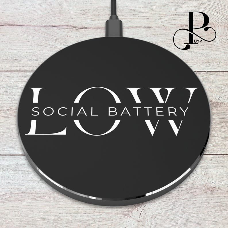 May include: A black wireless charging pad with a white logo that says "LOW SOCIAL BATTERY LOW".