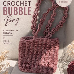 Peut inclure: Un sac à bulles au crochet rose poudré avec un motif texturé et des anses assorties. Le sac est fait à la main et adapté aux débutants, avec un tutoriel étape par étape et un support vidéo. Le design est moderne et élégant.