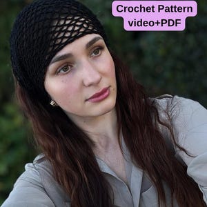 May include: A black crochet hat with a net-like design. The hat is worn by a person with long brown hair and a light gray shirt. Text on the image reads "Crochet Pattern video+PDF".