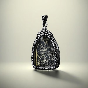 May include: A silver-toned pendant with an ornate, filigree-style frame. The pendant features a detailed, dark-colored relief of a figure with a dragon. The bail is a stylized design. The pendant is likely made of metal.