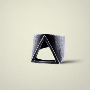 Könnte beinhalten: Ein silberfarbener Ring mit einem geometrischen Dreiecks-Ausschnitt. Der Ring hat ein breites Band und eine strukturierte, oxidierte Oberfläche. Das Dreieck ist mittig auf dem Ring platziert und erzeugt einen kühnen, modernen Look. Der Ring ist ein Schmuckstück.