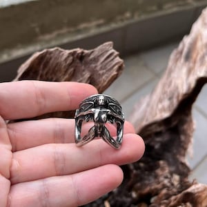 Puede incluir: Anillo de plata con una figura femenina estilizada, con los brazos extendidos y el pelo suelto. El diseño del anillo incorpora una representación detallada del cuerpo de la mujer, creando una joya única y artística.