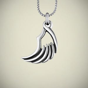 Op de afbeelding: Een zilverkleurige ketting met een hanger in de vorm van een gestileerde vleugel. De hanger heeft een gebogen vorm met meerdere parallelle lijnen, hangend aan een fijne ketting. De ketting wordt getoond tegen een zachte, neutrale achtergrond.