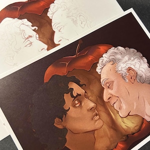 May include: Art print depicting two men in a detailed illustration, set against a red apple backdrop. The artwork uses warm tones, highlighting facial expressions and character interaction. The print is on white paper.