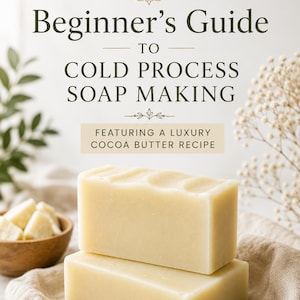 Puede incluir: Una portada de libro titulada Etti Soap Beginner's Guide TO COLD PROCESS SOAP MAKING FEATURING A LUXURY COCOA BUTTER RECIPE. La imagen muestra dos pastillas de jabón rectangulares de color blanco roto apiladas sobre un paño beige y un cuenco.
