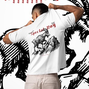 May include: White t-shirt with the text "Special Boy" in red and a graphic of a mountain goat. The shirt also features the text "aaaaahhh" and "forsaken aerialist". The shirt is being held up by a person.