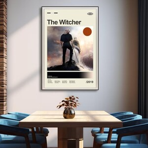 Pu&ograve; includere: Un poster incorniciato con il titolo "The Witcher" in nero. Il poster ha uno sfondo beige con un'immagine di due figure su un affioramento roccioso. Un grande cerchio color ruggine &egrave; sopra l'immagine. L'anno 2019 &egrave; in basso.